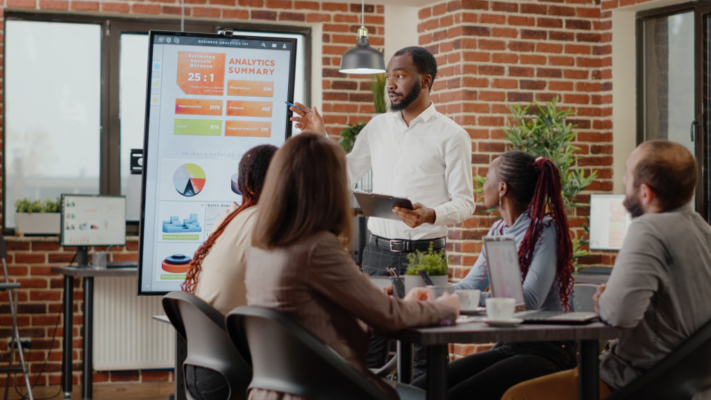 company employee presenting business strategy with charts monitor planning project workmates analyzing financial statistics display working together company development (1)