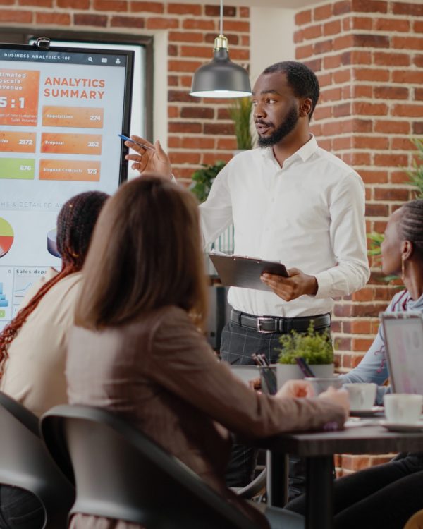 company employee presenting business strategy with charts monitor planning project workmates analyzing financial statistics display working together company development (1)